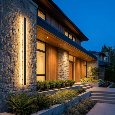 Long black outdoor LED bar light glowing on a modern villa facade at dusk